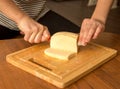 Slicing cheese with a knife on the board Royalty Free Stock Photo