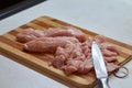 Slicing chicken breast on chopping broad