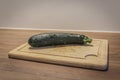 A slicing cucumber cut on a wooden cutting board