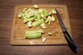 A slicing cucumber cut on a wooden cutting board and a knife