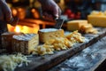 Slicing different cheeses lying on a wooden board against the background of the kitchen Royalty Free Stock Photo