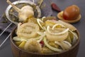 Slicing fermented green tomatoes and cucumbers with onions pickled garlic in a wooden bowl on a gray table. Royalty Free Stock Photo