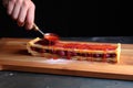slicing finished raspberry tart on wooden board