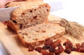 Slicing fresh bread, ears of wheat and raisins