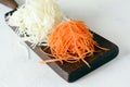 Slicing Fresh cabbage and carrots on a wooden board on a light background. Vegetables for ferment, for long fermentation. Royalty Free Stock Photo