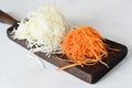 Slicing Fresh cabbage and carrots on a wooden board on a light background. Vegetables for ferment, for long fermentation. Royalty Free Stock Photo