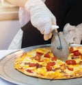 Slicing Fresh Made Italian Pizza, Closeup hand of chef cutting pizza in kitchen Royalty Free Stock Photo