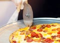 Slicing Fresh Made Italian Pizza, Closeup hand of chef cutting pizza in kitchen Royalty Free Stock Photo