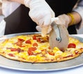 Slicing Fresh Made Italian Pizza, Closeup hand of chef cutting pizza in kitchen Royalty Free Stock Photo