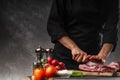 Slicing fresh meat, pork ribs on a background of fresh vegetables and a gray wall with space Royalty Free Stock Photo