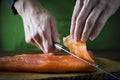 Slicing gravlax salmon with a knife Royalty Free Stock Photo