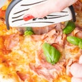 Slicing ham pizza with roller knife from above