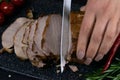Slicing juicy beef steak by knife in women hands closeup. Food cooking concept. Dark black background