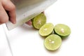 Slicing lime with knife on white cutting board