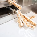 Slicing machine cutting hand-made French almond and honey nougat