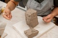 Slicing off a chunk of clay from a large block using a sharp wire clay cutter. Using a wire cutter to cut off a piece of