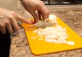 Slicing onions with a knife on the board Royalty Free Stock Photo
