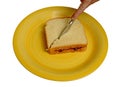 Slicing peanut butter and jelly sandwich on a yellow plate Royalty Free Stock Photo