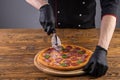 slicing pizza on a wooden background for a restaurant menu1 Royalty Free Stock Photo