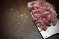 Slicing raw pork on wooden chopboard