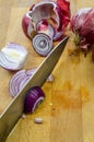 Slicing Red Onions on a wooden cutting board with kitchen knife close up