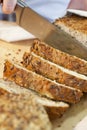 Slicing Rustic Wholemeal Seeded Loaf of Bread Royalty Free Stock Photo