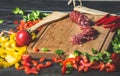 Slicing sausage on cutting Board with ingredients