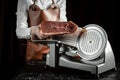 Slicing Spanish jamon iberico on cutting machine. Spanish jamon and traditional food. gastronomic products of Spain Royalty Free Stock Photo