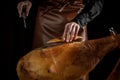 Slicing Spanish jamon iberico. Hands of a women cut a slice of traditionally spanish jamon. Spanish jamon and traditional food