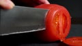 Slicing the tomato. Black background. HD video.