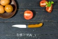 Slicing tomatoes with a pocket knife. Royalty Free Stock Photo