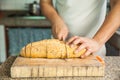 Slicing a whole grain bread with a knife Royalty Free Stock Photo