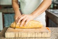 Slicing a whole grain bread with a knife Royalty Free Stock Photo