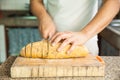 Slicing a whole grain bread with a knife Royalty Free Stock Photo