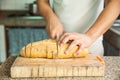 Slicing a whole grain bread with a knife Royalty Free Stock Photo