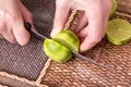 Slicing zested lime with knife. Royalty Free Stock Photo