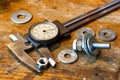 Slide caliper with round scale and bolt with nuts on the workbench in workshop Royalty Free Stock Photo