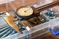 Slide caliper with round scale and screws in storage box on a wooden table Royalty Free Stock Photo