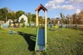 Slide and swings with a wooden house on children playground. Outdoors games for kids. Summer bright day Royalty Free Stock Photo