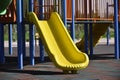 Slide and swings with a wooden house on children playground. Outdoors games for kids. Summer bright day. Royalty Free Stock Photo