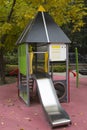 Slide wooden gray steel green in the form of a house in the yard of a residential complex. Playgrounds,