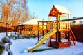 Slide with yellow wooden gazebo on the Playground for children in the yard on a Sunny winter day