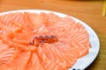 Slided Raw Salmon in white dish on wood blackground