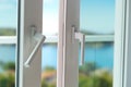 Sliding door of a balcony. Close-up of the lock on the door with and nice landscape of background. Royalty Free Stock Photo