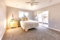 Sliding glass door allows warm light to flood this master bedroom in San Diego model home Royalty Free Stock Photo