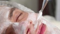 Sliding shot of a man getting facial mask applied by cosmetologist at spa center