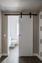 Sliding wooden toilet door hanging on exposed rail