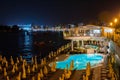 Tourists relaxing near a swimming pool at night Royalty Free Stock Photo