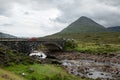 Sligachan New Bridge with one arch built from stones with driving cars and a landscape with the Sgurr Mhairi hill in background