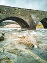 Sligachan Old stone Bridge over River Sligachan with Beinn Dearg Mhor and Marsco peak of Red Cuillin mountains in Royalty Free Stock Photo